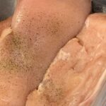 Raw chicken breasts with salt and pepper