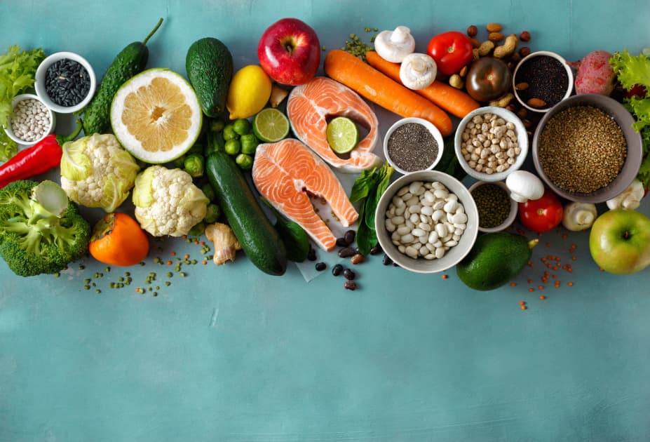 Display of colorful food including salmon, fruits, vegetables, and grains