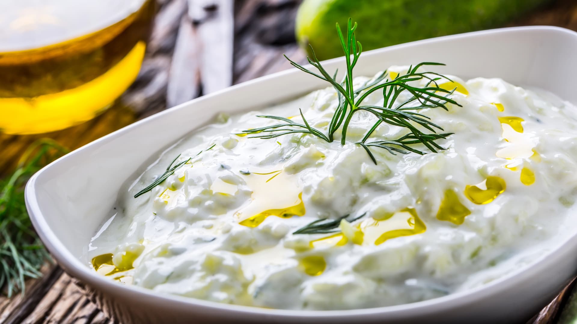 Image of Tzatziki sauce with a drizzle of olive oil and a spring of dill