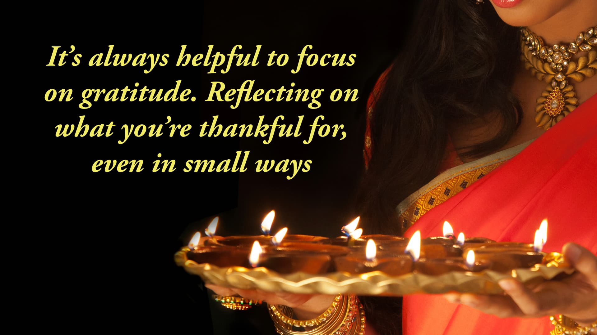 dark background image with a woman holding a tray of lights and the words It’s always helpful to focus on gratitude. Reflecting on what you’re thankful for, even in small ways