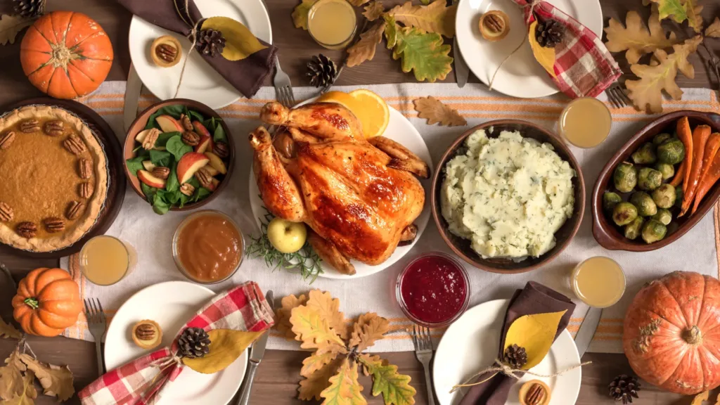 a Thanksgiving meal photographed from the top, it shows a turkey, mashed potatoes, some vegetables, cranberry sauce, and gravy
